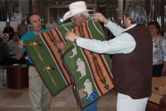 Southern Ute Indian Tribal Councilman Howard D. Richards Sr. receives a blanket from colleagues Aaron V. Torres and Vice Chairman James M. Olguin. Friends and family members joined employees of the Southern Ute Permanent Fund for a farewell ceremony for Richards and Joycelyn Dutchie, whose terms are expiring, in the lobby of the Leonard C. Burch Building on Monday, Dec. 3. Richards is running for re-election and will appear on the ballot during the Friday, Dec. 14 runoff election at the SunUte Community Center.