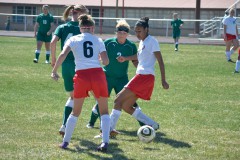 Ignacio's Amya Bison (14) and Tristan Boone (6) try shielding the ball away from Ridgway's Alma Johnson (2) and Emily Mandaville (4) during SWL play Saturday, April 13 at IHS Field.