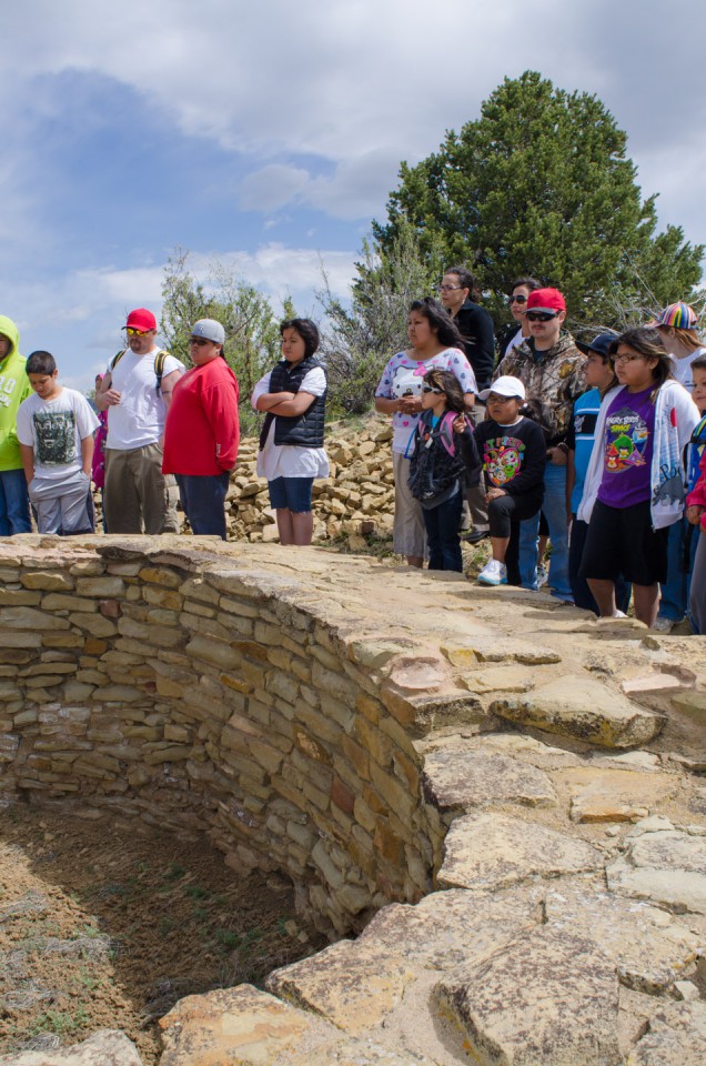 Students, teachers and family stand together as an interpretive guide gives some historical context on one of the many kivas unearthed throughout the Pueblo site.