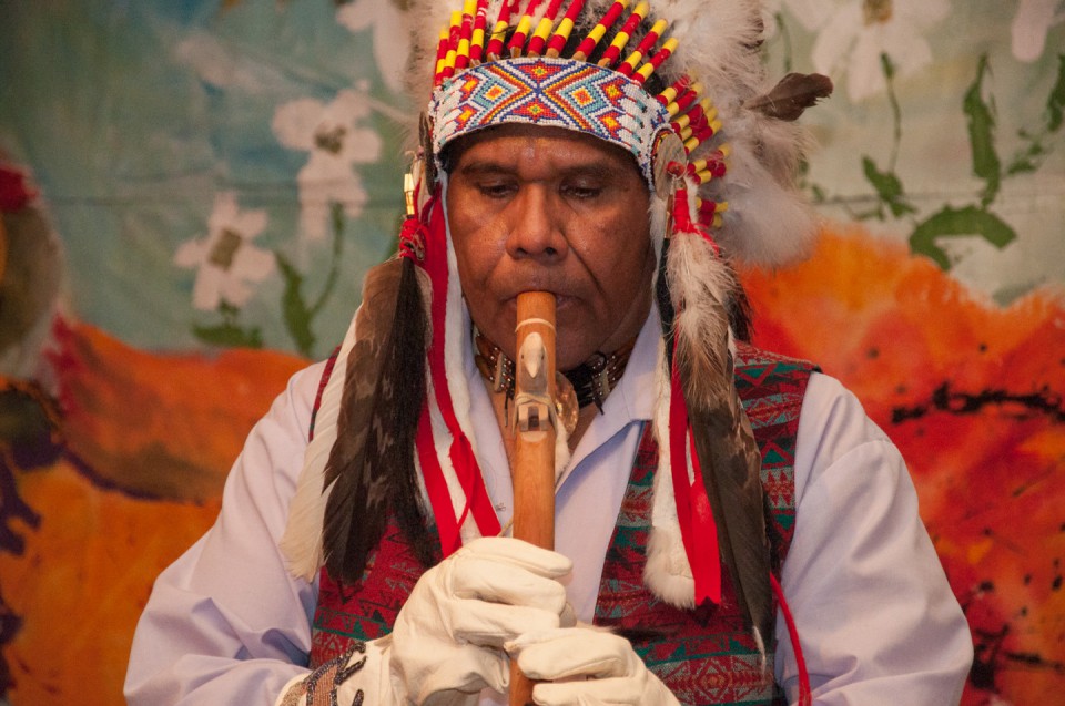 Tribal member Nathan Strong Elk plays a traditional tune on a flute during the art show, which also featured artisan foods and a variety of performances.
