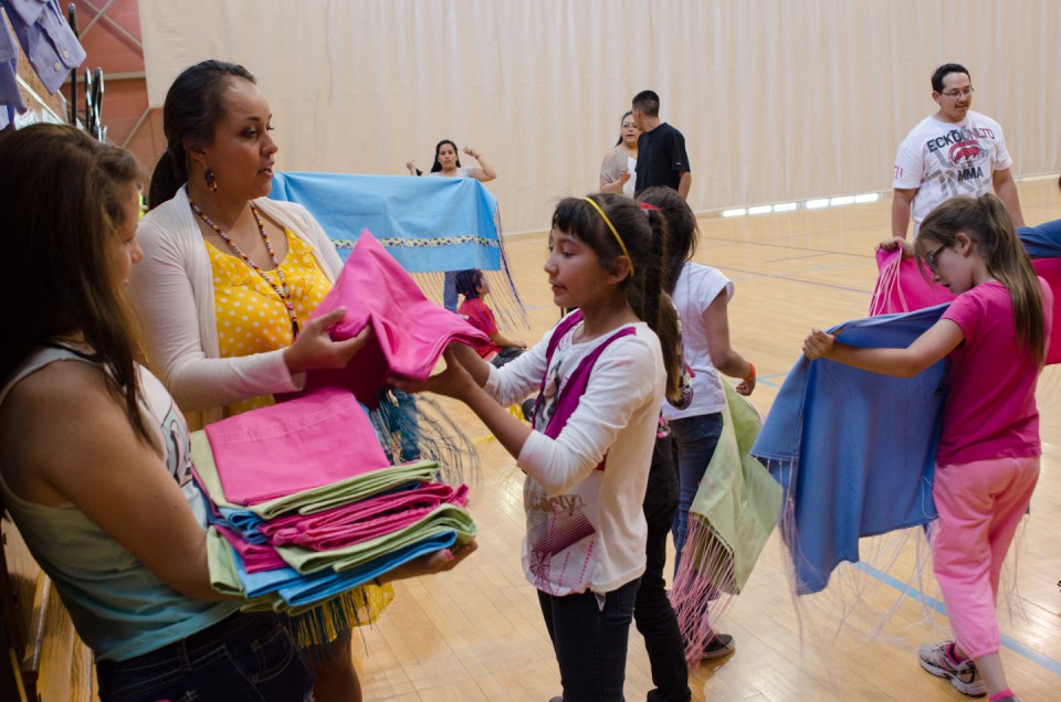 Lindsey Box hands out shawls to workshop participants.