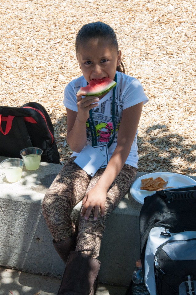 Young tribal member D’Vondra Garcia takes a break in the shade with a slice of watermelon.