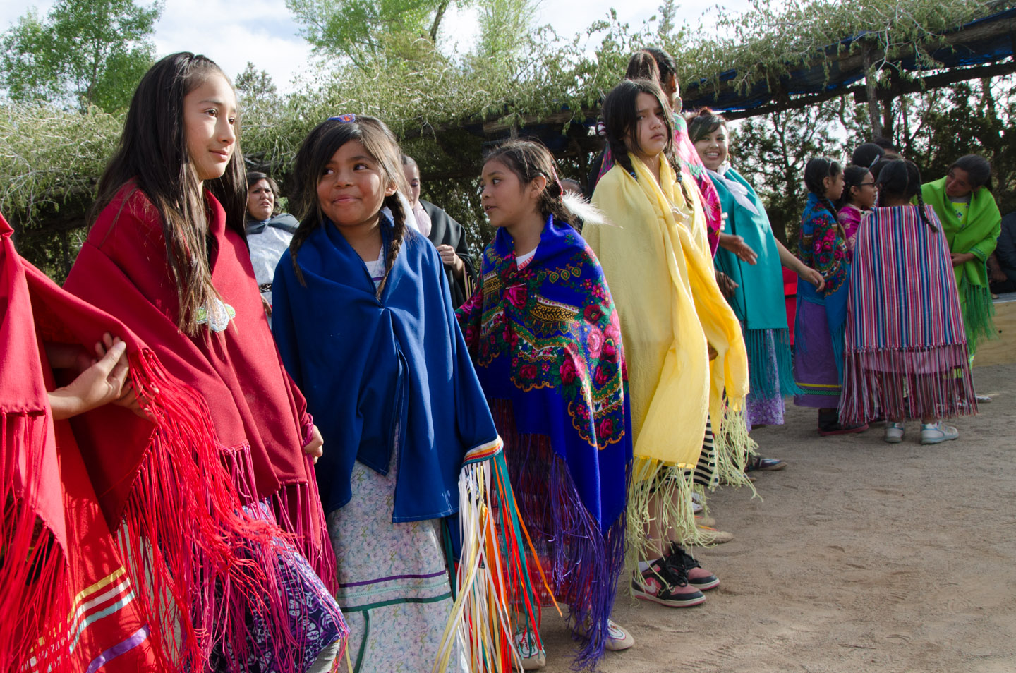 Girls, each wrapped in a colorful shawl, eagerly await the opportunity to pick out their dance partners in this women's choice dance.