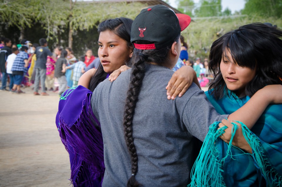 A pair of young women hold their partners tight during the Bear Dance.