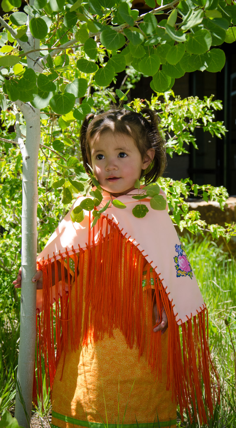 Young Southern Ute tribal member Neeka Ryder adorns a traditional dress and shawl for the spring Bear Dance.