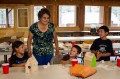 Thumbnail image of Southern Ute elder Evelyn Russell works with camp participants to construct wooden birdhouses, which the students painted themselves.