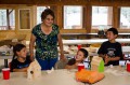 Thumbnail image of Southern Ute elder Evelyn Russell works with camp participants to construct wooden birdhouses, which the students painted themselves.