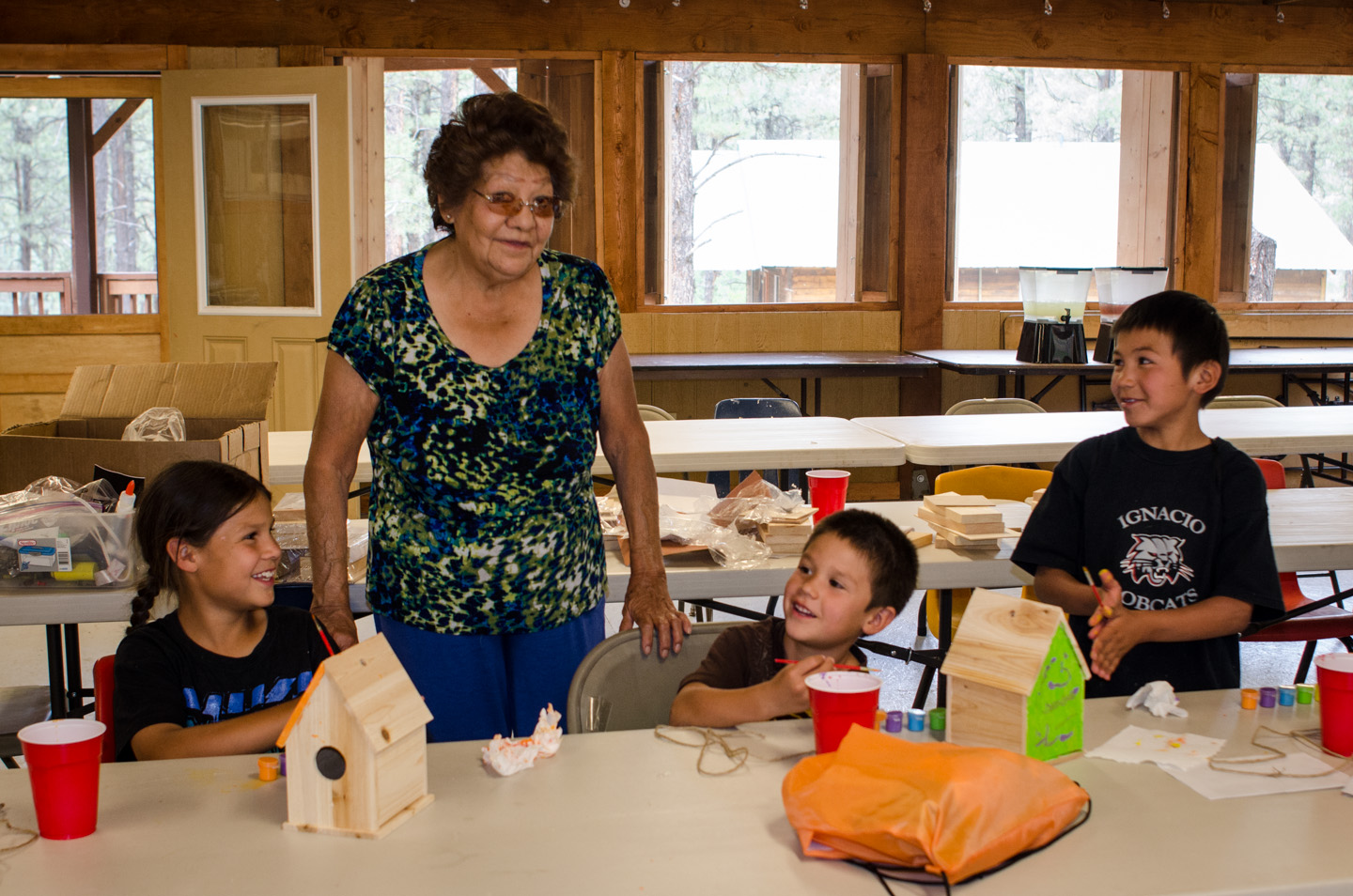 Southern Ute elder Evelyn Russell works with camp participants to construct wooden birdhouses, which the students painted themselves.