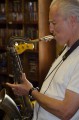 Thumbnail image of Saxophone player Joe Cabral tunes up. Cabral also sings and plays keyboards and the bajo sexto, a guitar-like Mexican string instrument with 12 strings. Also in the band are Doug Garrison (percussion) and Rod Hodges (guitar, accordion, vocals).