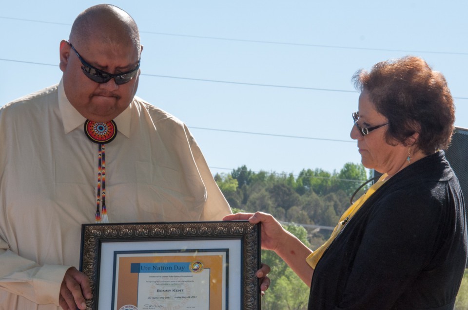 Southern Ute Indian Tribal Councilman Alex Cloud accepts an award from Culture Department Director Elise Redd on behalf of his grandfather, Bonny Kent, who died in 1989.