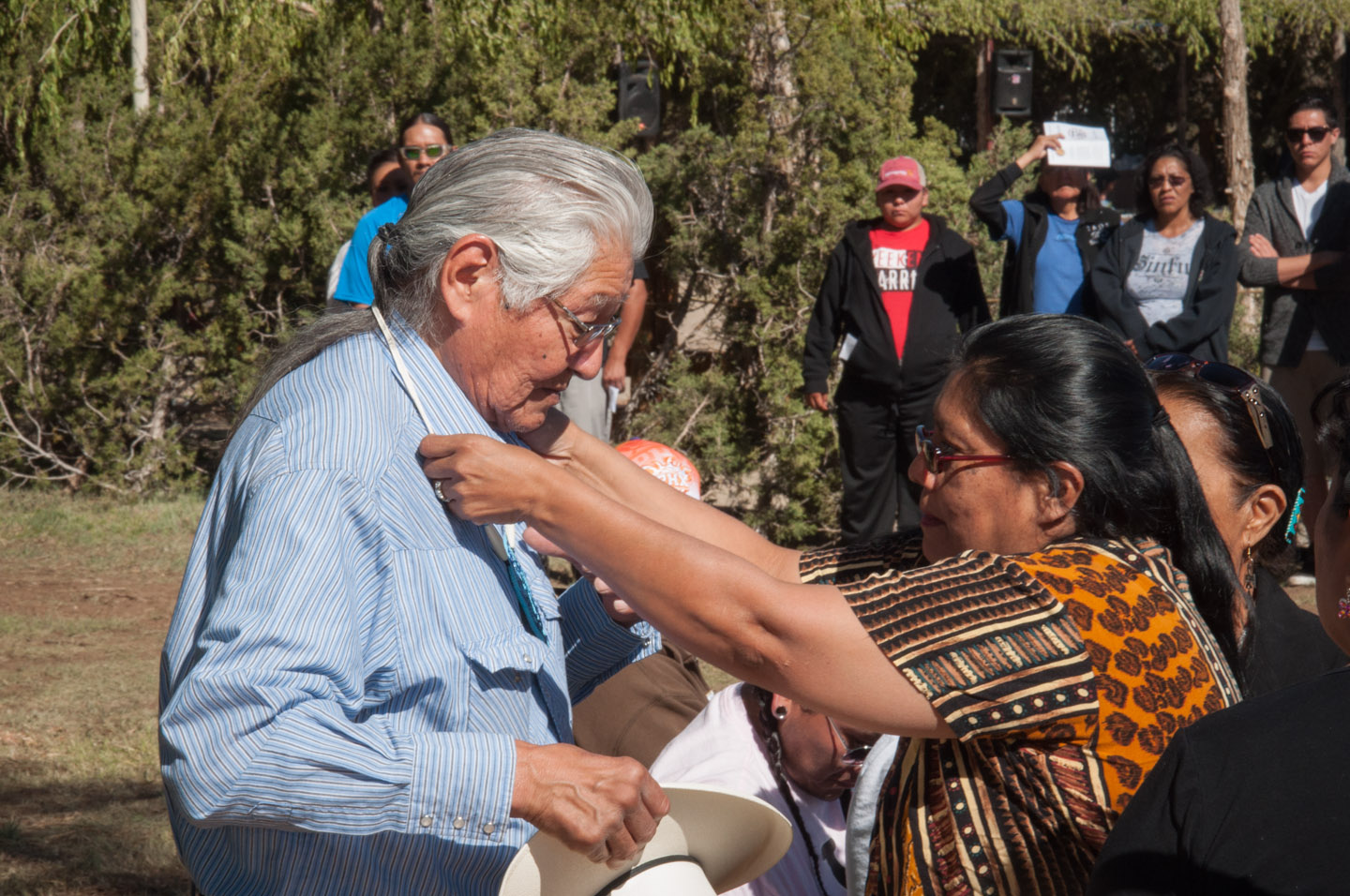 Southern Ute elder Alden Naranjo Jr., who ran the ceremony, accepts a beaded necklace from the family of one of the honorees.