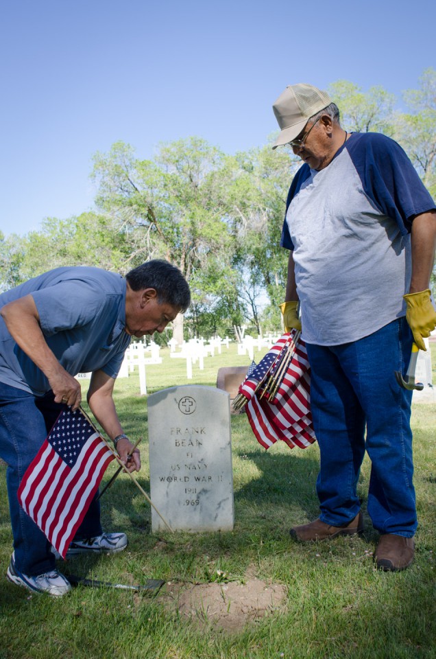 Grove and Baker uphold a long standing tradition, carefully placing the American flag on various headstones, honoring past service members.