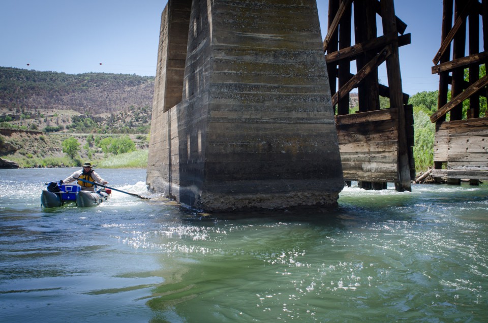 Navigating a short section of rapids, Pete Nylander travels south toward the New Mexico state line, passing under a historic railroad bridge spanning the Animas River. The Animas, known as the “river of lost souls,” has a reputation for its many dangers to those travelling the rocky watercourse.