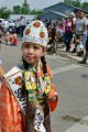 Thumbnail image of Little Miss Southern Ute Yllana Howe walks down Mill Street handing out fans to onlookers.