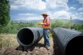 Thumbnail image of Chris Chambers, soil and water conservationist for the Southern Ute Indian Tribe’s Water Resources Division readies a 30-foot section of culvert for placement on the Dr. Morrison Canal emergency stabilization project.