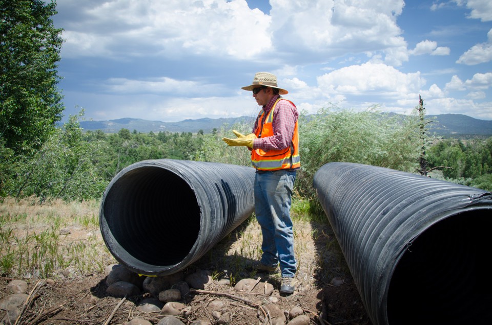 Chris Chambers, soil and water conservationist for the Southern Ute Indian Tribe’s Water Resources Division readies a 30-foot section of culvert for placement on the Dr. Morrison Canal emergency stabilization project.