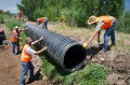 Thumbnail image of Crew members from the Southern Ute Indian Tribe’s Department of Natural Resources work together with the U.S. Bureau of Indian Affairs to set plastic ADS culvert on Tuesday, July 9, to stabilize the damaged canal in an effort to restore water flow by the end of the week.