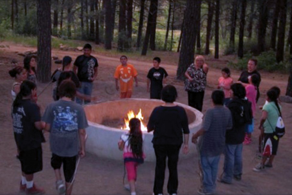 Youth and chaperones gather around the fire put for prayers and s’mores on Wednesday, June 26.
