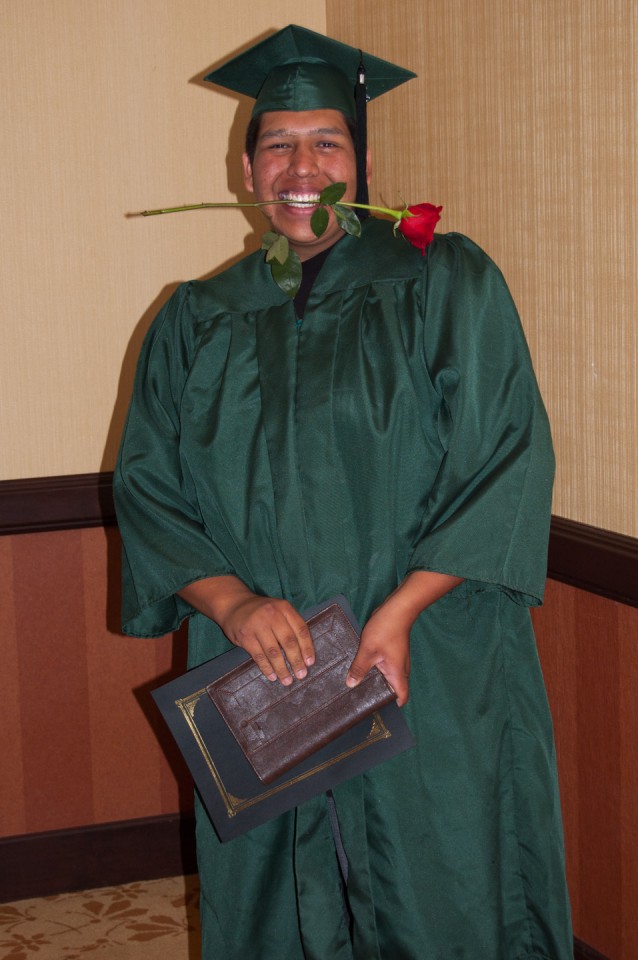 GED graduate Hiram House celebrates his graduation with a rose between his teeth before taking a bow.