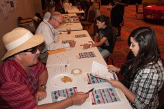 Steve Govreau, purchasing manager for the Southern Ute Indian Tribe, tries to sell a car to Aspen Baker during Mad City Money, a financial management exercise, on Tuesday, July 9 at the Sky Ute Casino Resort. The event aimed to teach participants in the tribe’s Youth Employment Program how to manage a budget. The Southern Ute Finance Department sponsored the exercise.