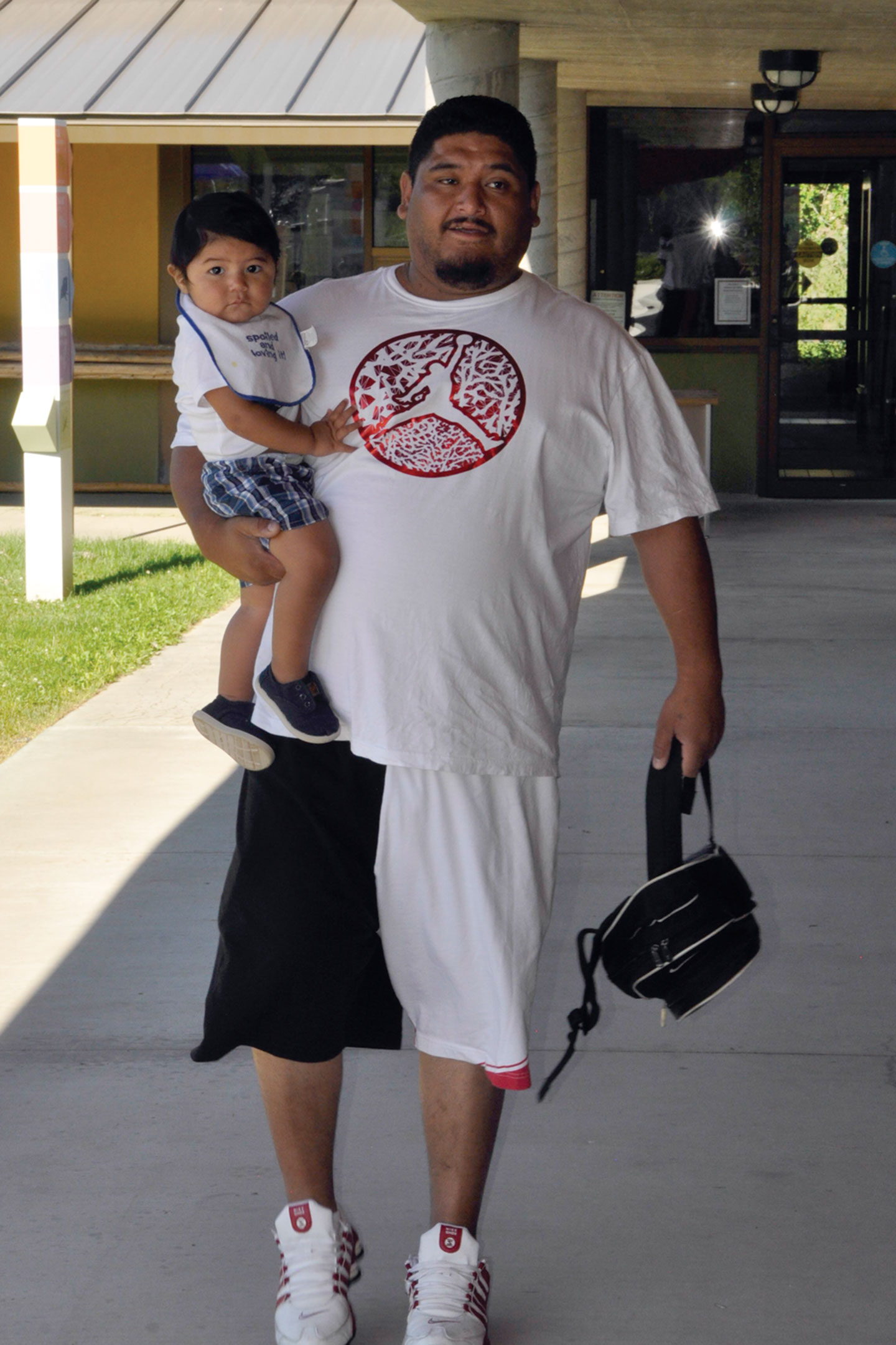 Mario Gonzalez carries toddler Cristovan