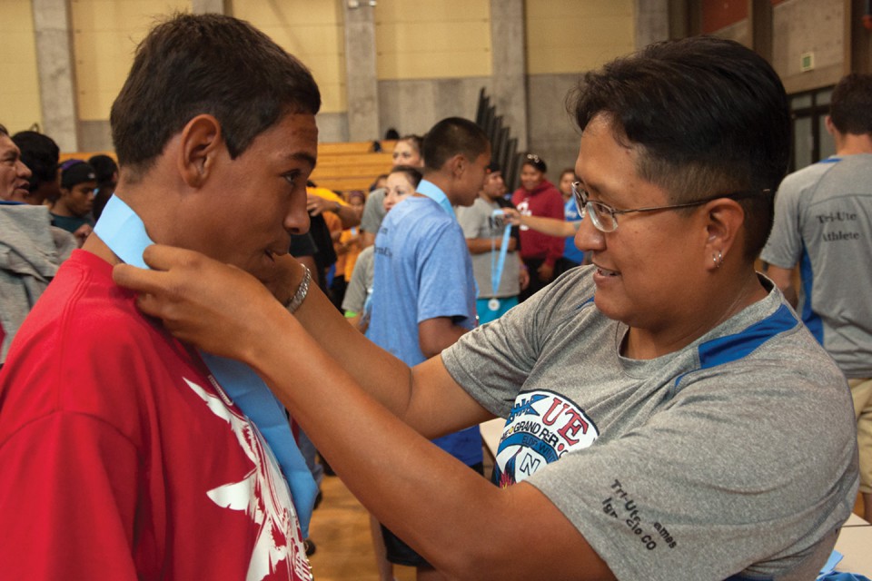 SunUte Community Center Director (right) Kristi Garnanez bestows a medal upon a Northern Ute participant.