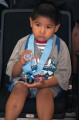 Thumbnail image of A young Southern Ute participant plays with his medal.