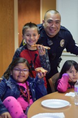 Club members enjoy their pizza with officer Ferlando Fonseca from the Southern Ute Police Department.