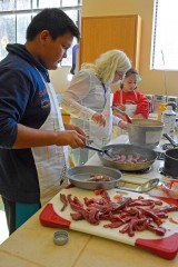 Elijah Weaver cooks the steak portion of the meal as Julie Stone, Public Ed. Teacher, helps D’Vondra Garcia make homemade mac and cheese as a part of team Healthy Feathers. The Iron Chef competition held at the Education Center on April 26.