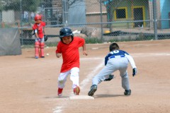 Ignacio Angels’ Angelo Frost (left) tags third and heads for home during play against Bayfield on Saturday, May 7 at the Riverview Sports Complex in Durango.