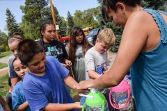 Boys & Girls Club members from Ignacio and Bayfield line up to fill their balloons for a water fight.