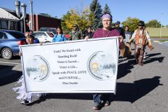 Angelo Frost (left) and Kasey Correia lead the banner titled, “Unite! We stand with Standing Rock!” Approximately 40 participants marched from SunUte Community Center to Scott’s Pond. 