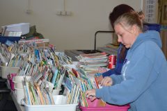 Headstart educators Amy Leach and Sabrina Black go through hundreds of books during the move to the museum.