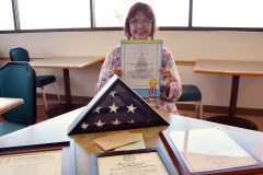 Former Southern Ute Tribal Judge, Elaine Newton proudly holds a certificate affirming that the American flag was flown over the Colorado Capitol in Denver, on January 8, 2016 in memory of her son, the late Jimmy Newton Jr. The flag was also presented to Mrs. Newton in a package given to her from former Colorado Senator, Ellen S. Roberts.