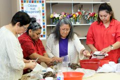 The Southern Ute Multi-Purpose Facility staff help yucca soap making instructor, Helen Munoz (middle) with getting the yucca root cut and cleaned, while she shows elders how she makes soap. 