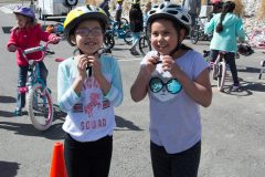 Ignacio Elementary School students Laila Charlie (left) and Lilliana Castro buckle their helmets before they start riding through the obstacles of the Bike Rodeo on Wednesday, April 4 in the school’s parking lot. The bike rodeo was sponsored by SUPD. 