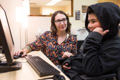 Nicole Cabral, Distant Learning Coordinator for the Southern Ute Education Department, mentors one of her students, Ayden Barry. The students meet for Code Club on a regular basis to master their coding skills in the computer lab.  