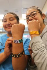 Jazmin Carmenoros and Grace Gonzales pose with loom bracelets they made at the Ute Museum in Montrose, Colo., Tuesday, June 19. 