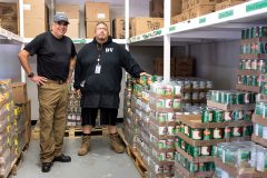 Food Distribution Program Division Head, Jeremy Cuthair (right) and Stock Clerk, Angelo Valdez stand in the warehouse supply room. Fresh fruits and vegetables, frozen meats and most other pantry staples are made available through the Tribe’s food program. 
