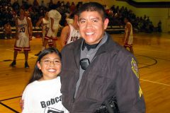 Chris Naranjo, working as a patrol sergeant for SUPD, stands with his daughter, Alicia, at an Ignacio High School basketball game in 2004. For Lt. Naranjo, the job is all about community service. 