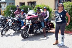Bikers ready themselves, as Sandra Red smiles and sees them off on the poker run.