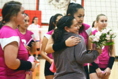 Following Ignacio’s Oct. 19 match versus Dove Creek, Volleycat junior Makayla Howell gives flowers and a hug to Trish Quintana, one of several survivors saluted inside IHS Gymnasium during a special National Breast Cancer Awareness Month ceremony.