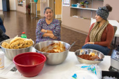 Luana Herrera and Marquetta Howe sit together while the masa for the tamales are prepared at the tamale cooking class held in the Multi-Purpose Facility, Tuesday, Nov. 13. 
