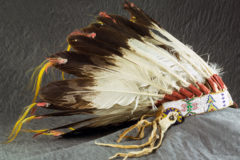 This headdress is made of glass seed beads, cotton thread, trade cloth, buckskin, thirty-two eagle feathers, brass buttons, chicken feathers, horsehair, and animal fur. It belonged to Antonio Buck, Sr. (1879–1961), the last hereditary chief of the Southern Ute Indian Tribe. He received it from his father, Buckskin Charley (1840–1936), who led many delegations to Washington, DC, to work on behalf of the tribe. It was made around 1890–1900. Frances Buck donated it to History Colorado. 84.32.1