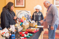 Southern Ute Cultural Preservation Director, Edward Box III places his bid on a cultural basket in the silent auction, put together by a young group of boys who are raising money to attend Space Camp next year.
 
