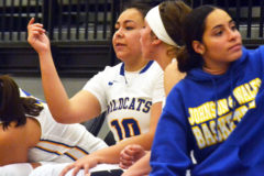 Now playing for Denver-based Johnson & Wales University, IHS alumna Allisianna Baker-Marquez (10) and a teammate ponder how a play should go while taking a bench break Friday afternoon, Nov. 23, in Colorado Springs versus East Texas Baptist University.