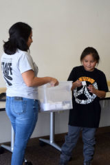 Boys & Girls Club Mentor Coordinator, Cassandra Sanchez holds the bin of raffle tickets while Uriyah Casey draws a winning ticket for the Elk Hunt Raffle on Friday, Dec. 28 in the conference room of the SunUte Community Center as part of their annual fundraiser. 

