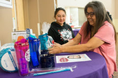 Raffle Prize winner, Luana Herrera, smiles as she picks out her raffle gift. For this Elders Dinner raffle prizes were donated by The Southern Ute Drum.