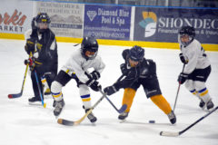 Durango Steamers, and Southern Ute tribal member, Keelyn Reynolds (in white jersey) battles for the puck on the ice in the Jorgensen indoor ice rink against a Pueblo Tigers player, Saturday, Feb. 9 in Gunnison, Colo. The Durango Steamers Mites division will conclude regular season play March 2-3.