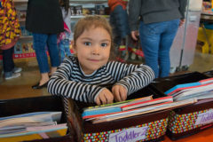O’hozhoni Larry browses through the books at the annual book fair held at the Southern Ute Indian Montessori Academy. 

